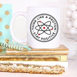 Tazza Mugffins Chimica 'Be A Proton. Stay Positive'. Tazza Da 350 Ml In Ceramica Bianca, Lavabile In Lavastoviglie E Microonde. Regalo Divertente Per Geek, Ingegneri E Amici.
